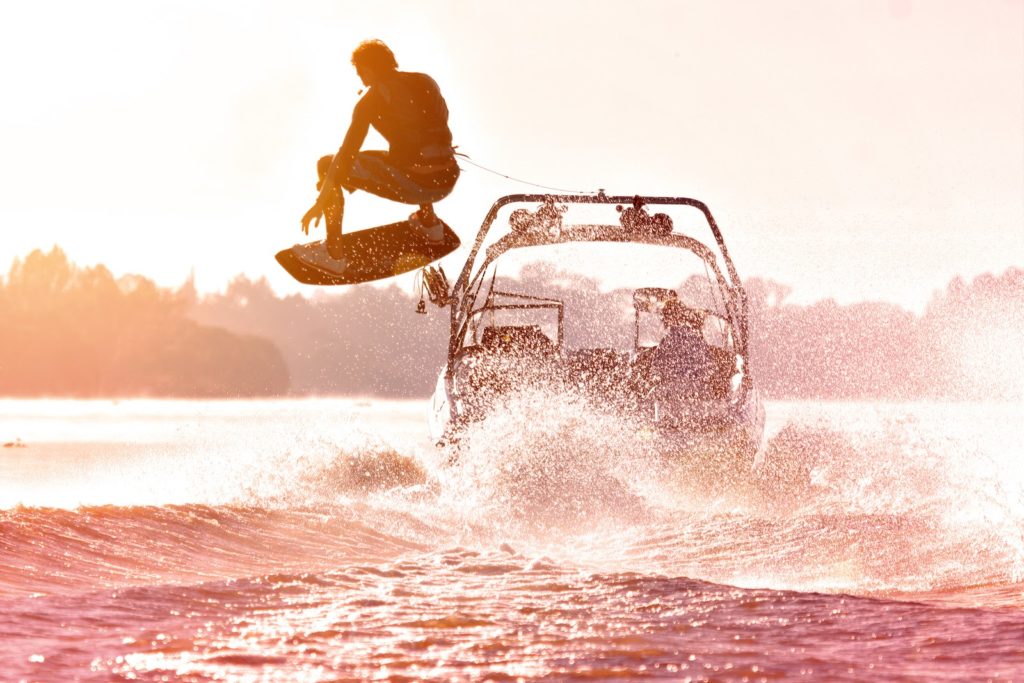 Wake boarder behind a boat on a lake